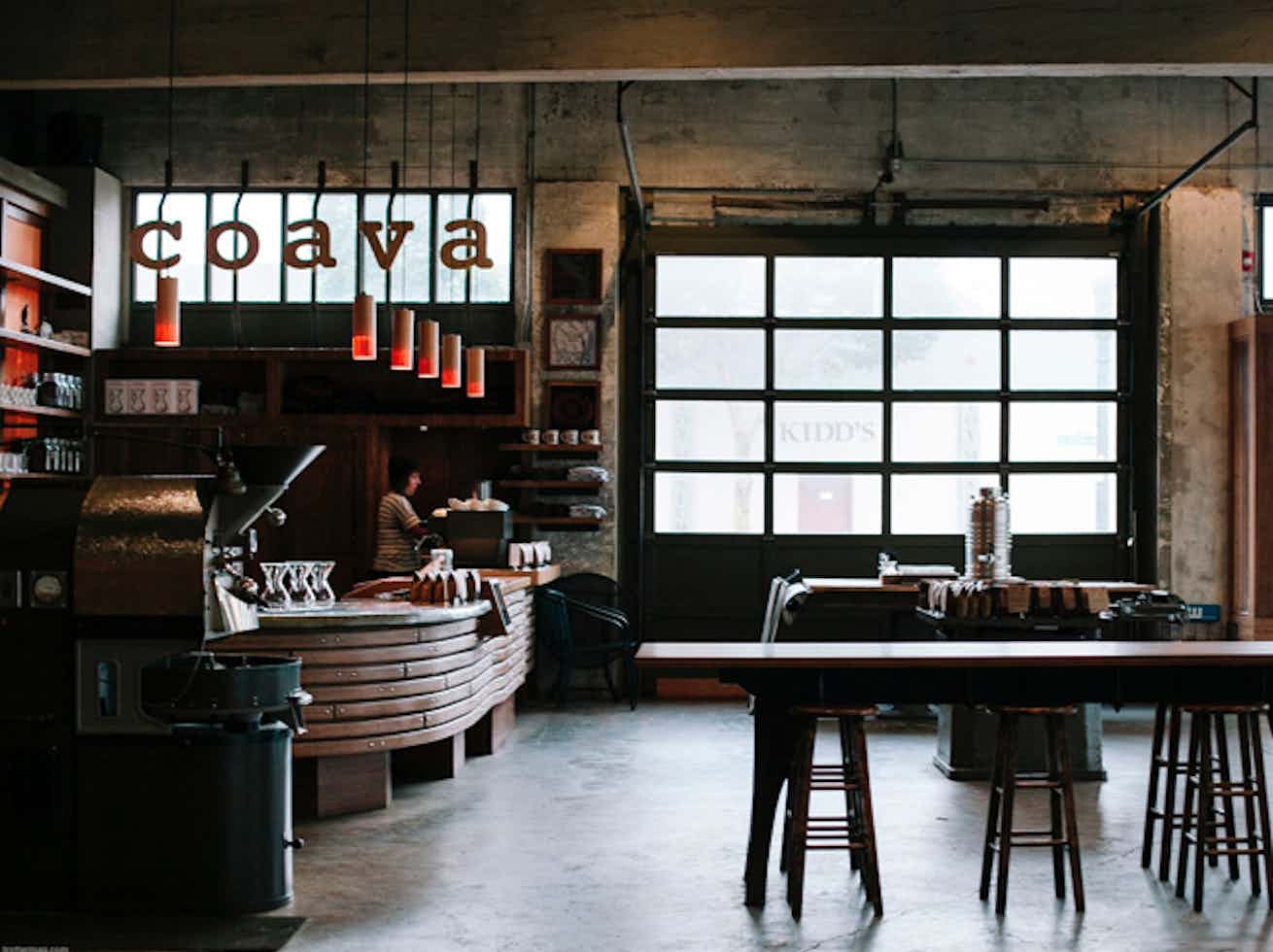 Airy coffee shop with large windows, wood accents, and polished concrete floors.